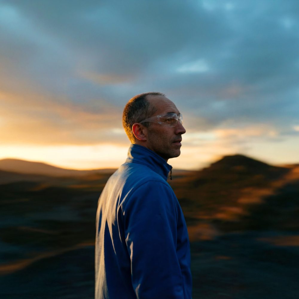 Man in rehlko shirt against a sunset
